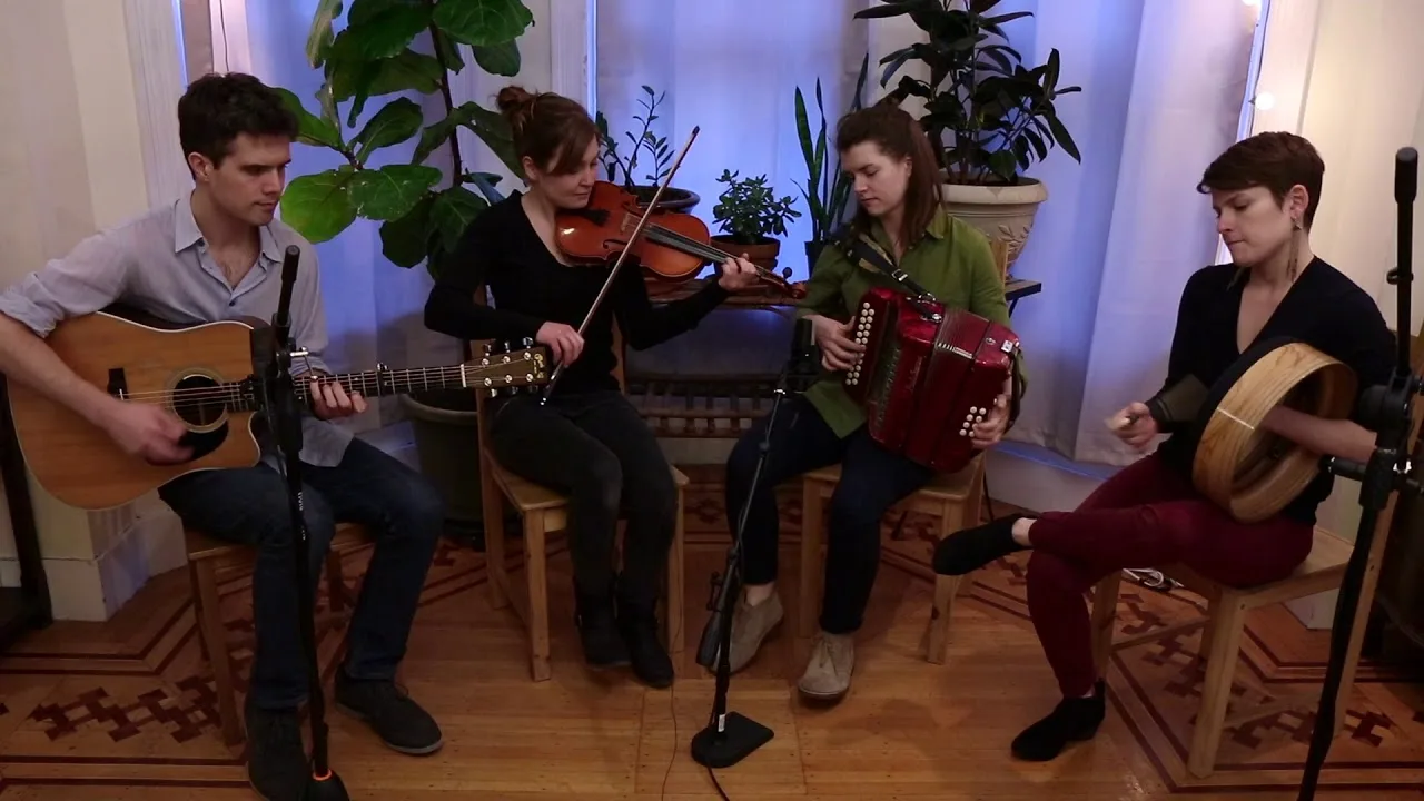 Ship in the Clouds playing in a sunlit room — guitar, fiddle, button accordion, and bodhrán
